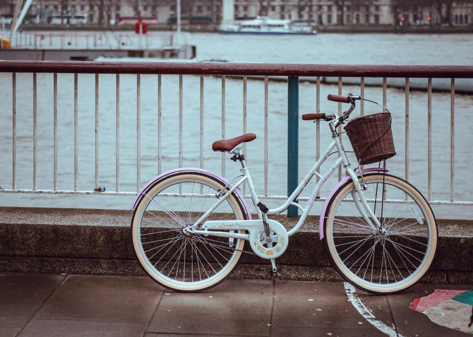 Free Image of Bicycle parked against bridge railing in city 