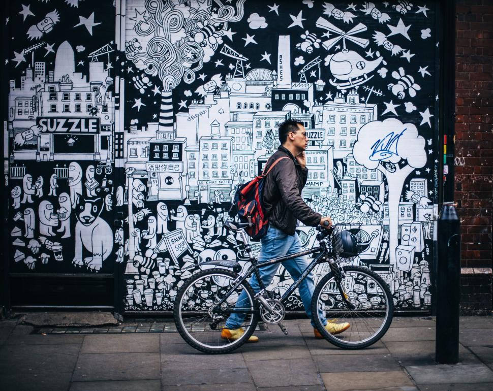 Free Image of Urban cyclist before dynamic graffiti wall backdrop 
