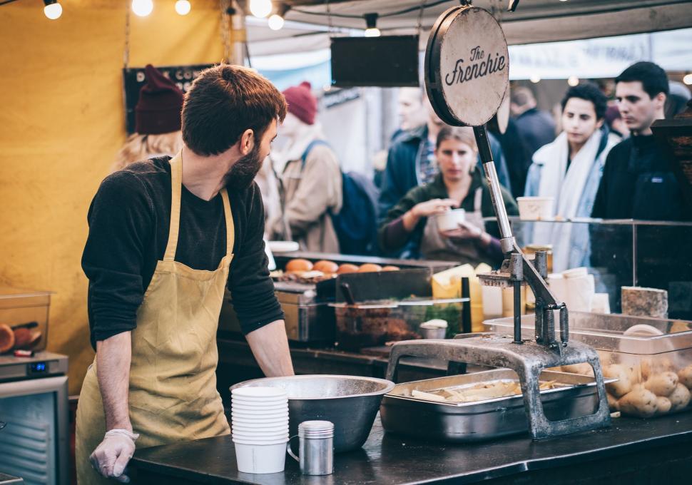 Free Image of Man serving food at a market stall 