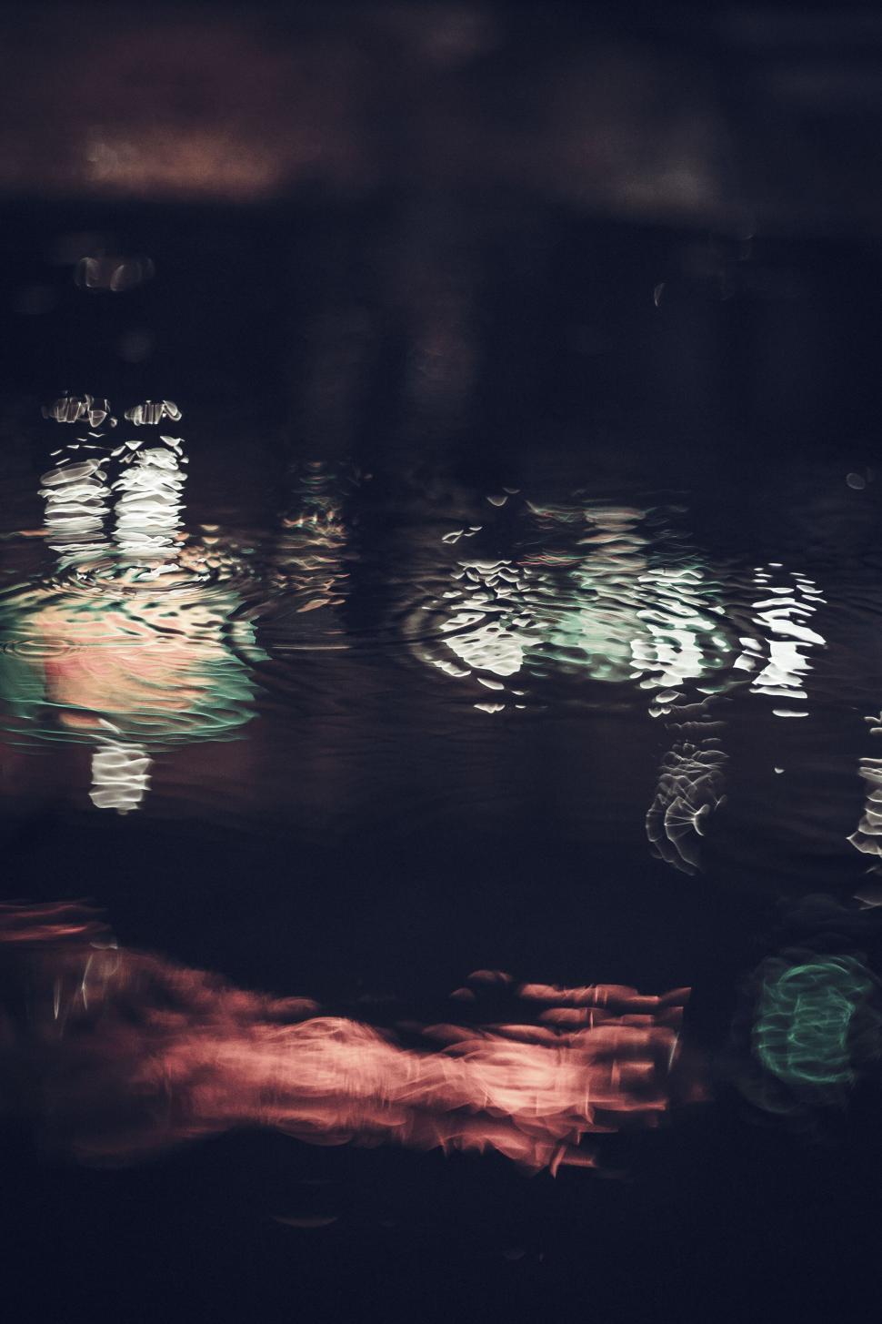 Free Image of Colorful reflections dancing on dark water 