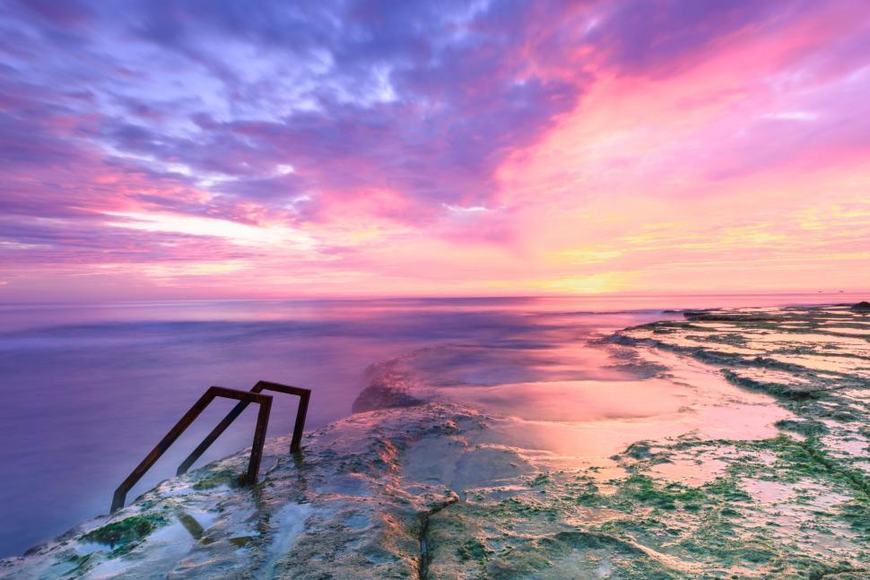 Free Image of Colorful sunrise over coastal rocks 