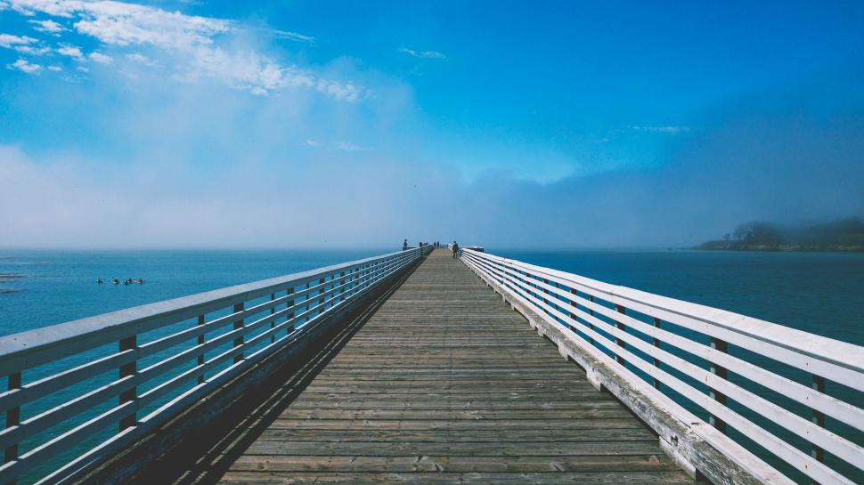 Free Image of Long wooden pier stretching into foggy waters 