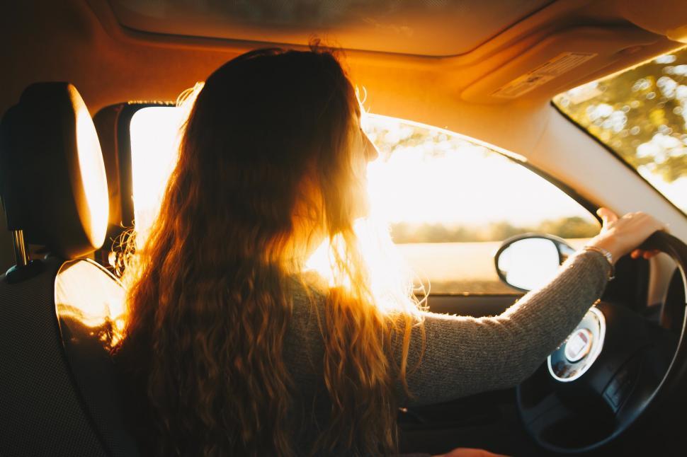 Free Image of Woman driving during a sunset journey 
