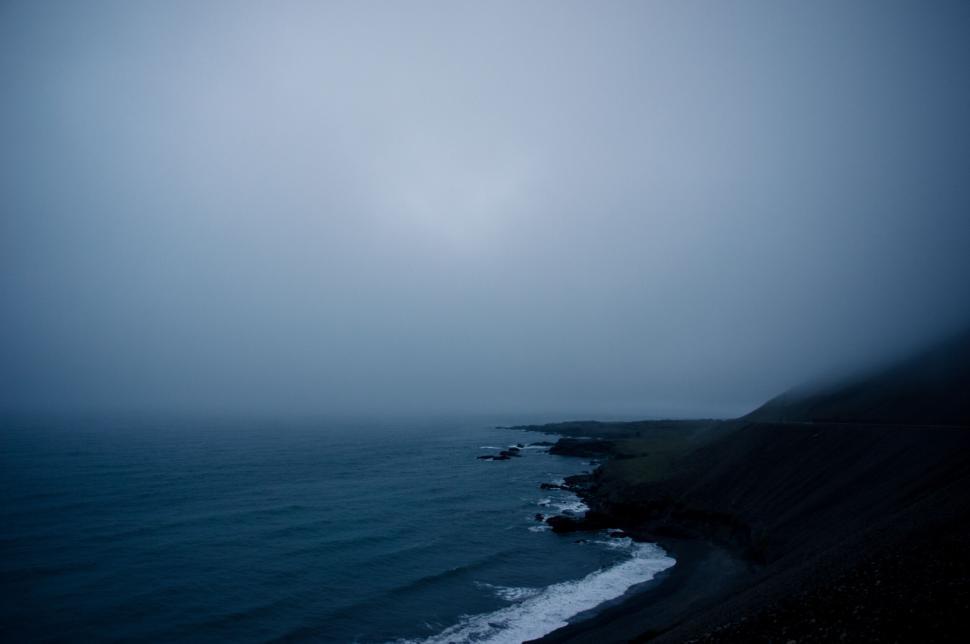 Free Image of Misty coastline with hills and dark waters 