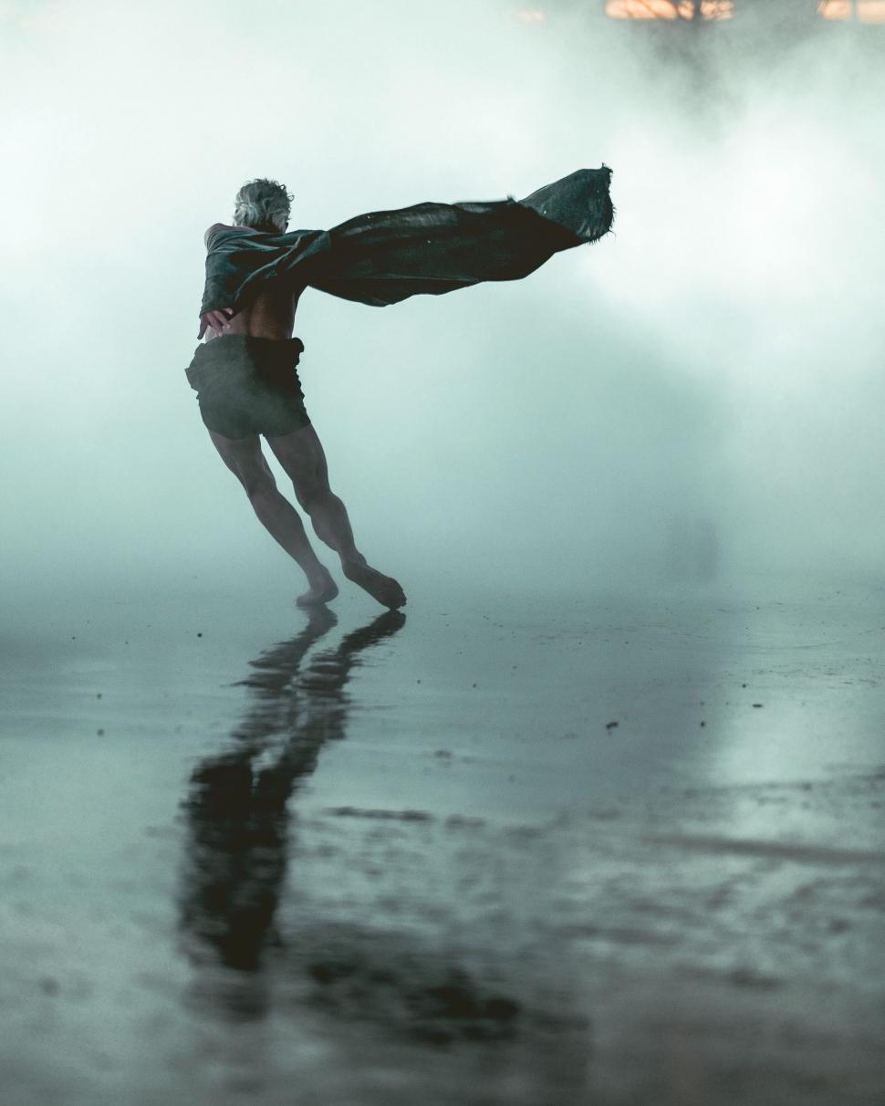 Free Image of Man twirling cloth on foggy day 