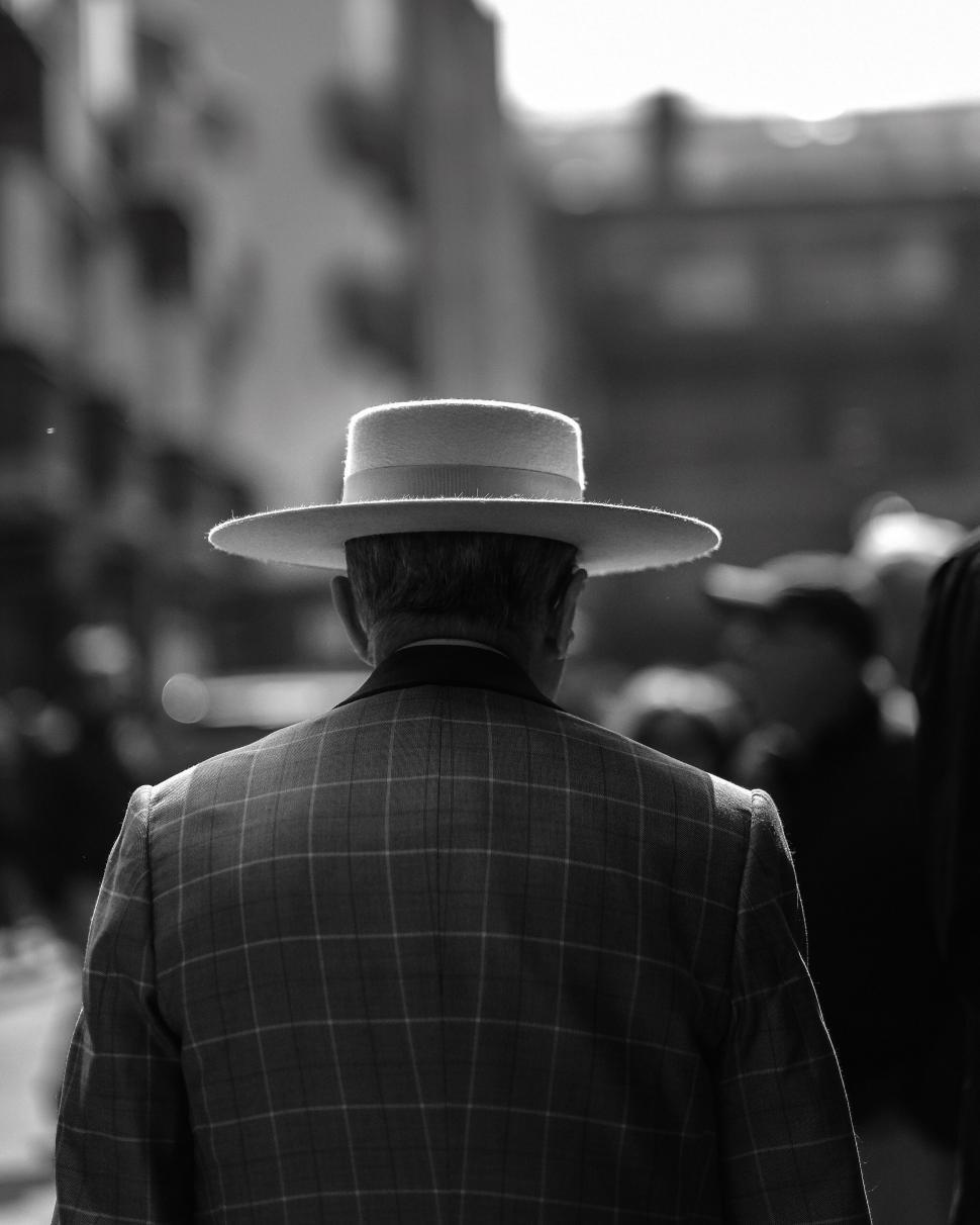 Free Image of Man in plaid suit and white hat from behind 