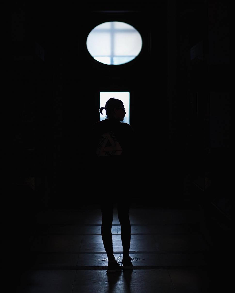 Free Image of Silhouette of person against circular window 