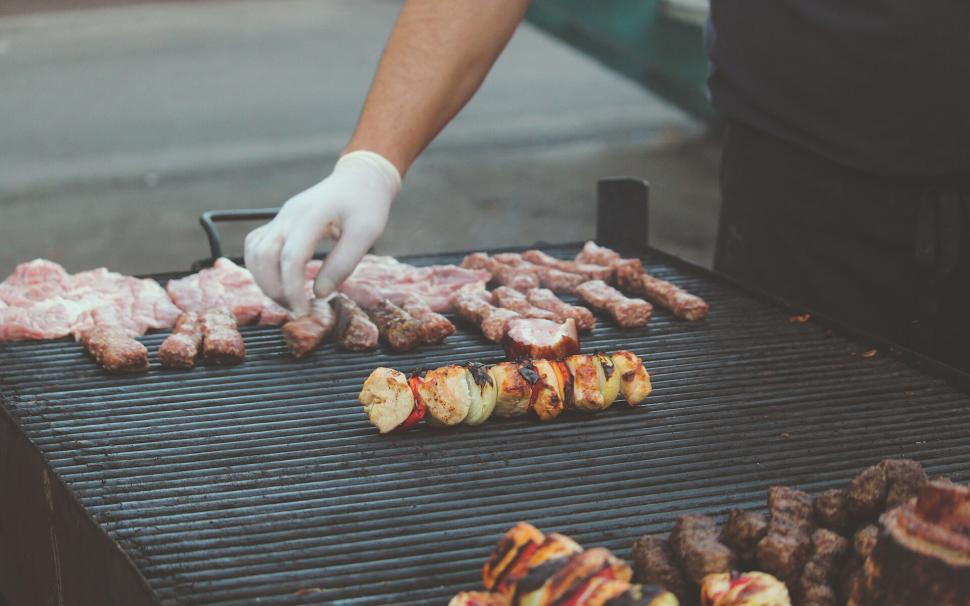 Free Image of Chef grilling assorted meats on outdoor BBQ 