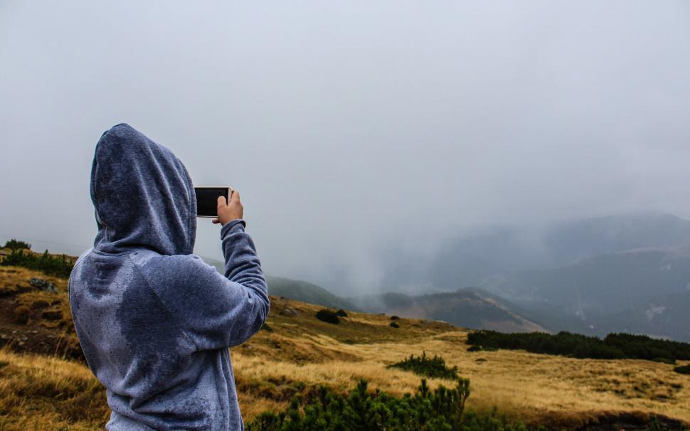 Free Image of Hooded person capturing foggy mountain view 