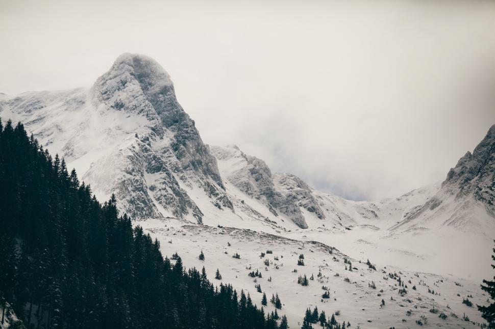 Free Image of Snow-covered mountain peak with clouds 