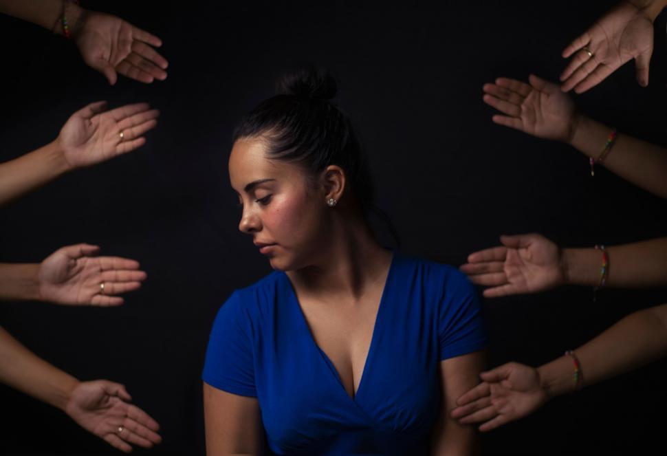 Free Image of Woman surrounded by outstretched hands 