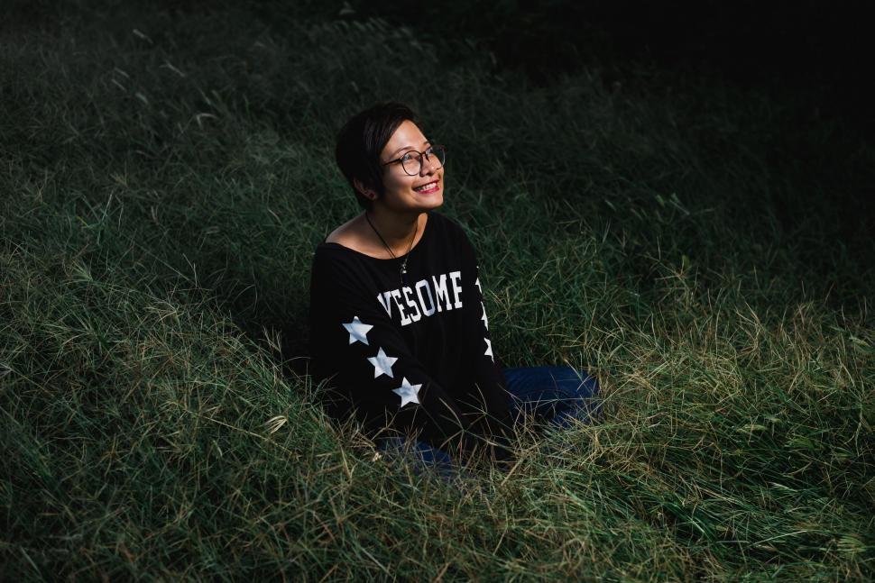 Free Image of Woman in grass smiling at twilight 
