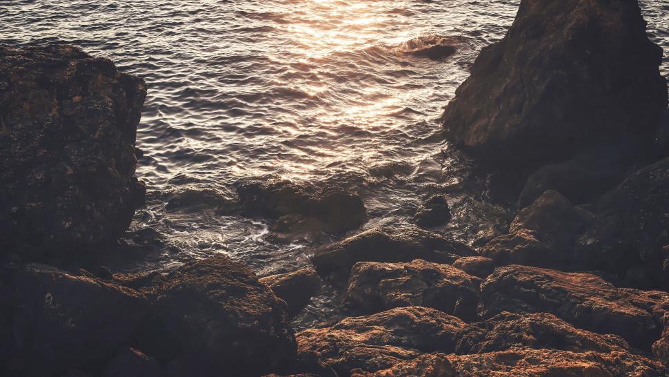 Free Image of Sunset glow on rocky seaside landscape 