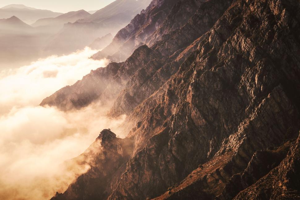 Free Image of Mountain cliffs enveloped in morning mist 