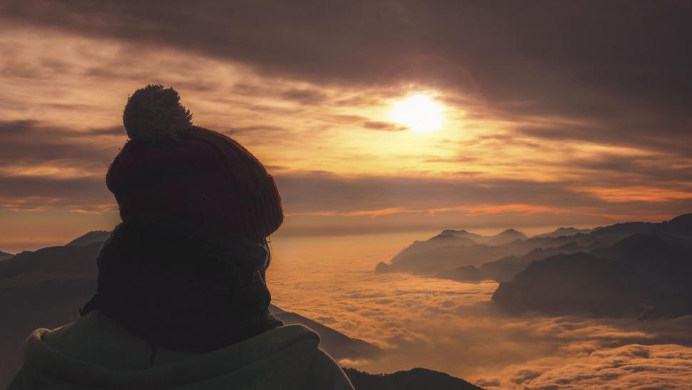 Free Image of Person gazing at sunrise over clouded mountains 