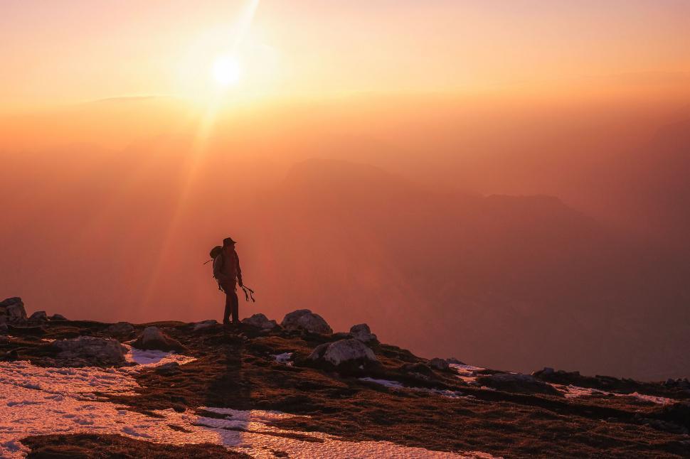Free Image of Hiker with backpack facing mountain sunrise 