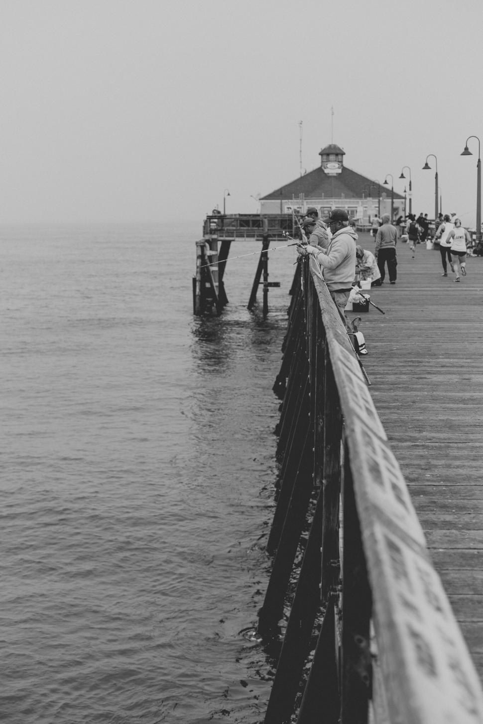 Free Image of Foggy pier with people strolling along 
