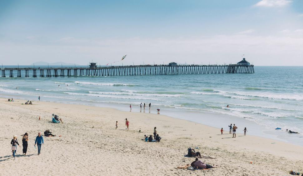 Free Image of Sunny beach scene with a bustling pier 
