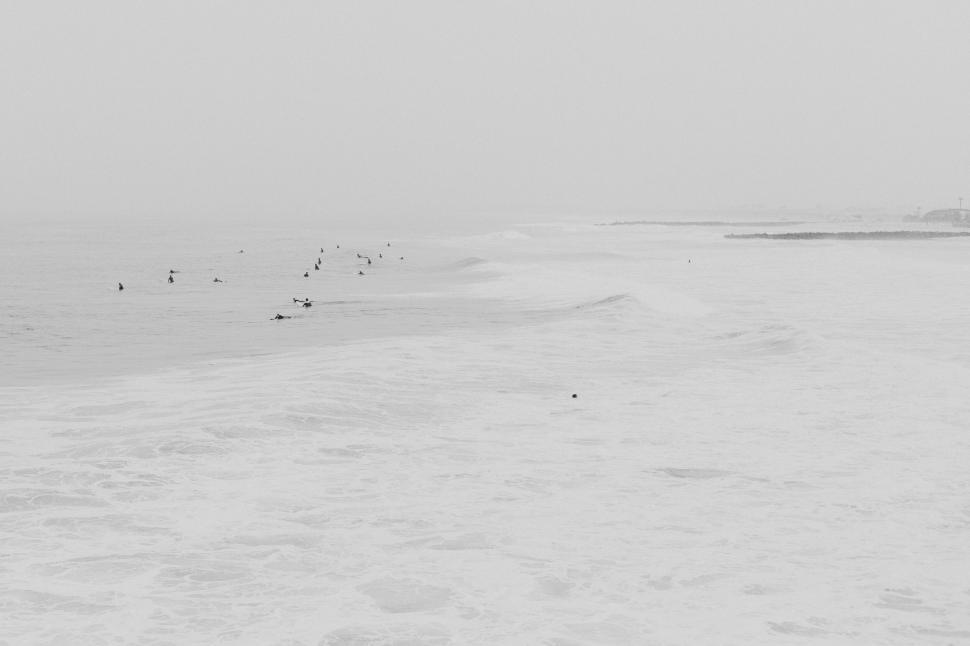 Free Image of Misty ocean waves with surfers waiting 
