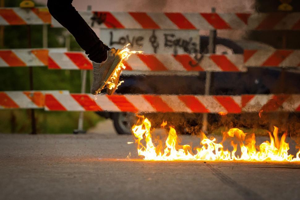 Free Image of Dynamic shoe stepping over fiery obstacle 