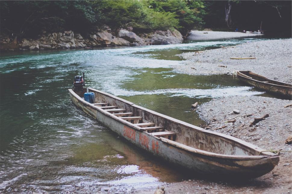Free Image of Solitary canoe on serene river s edge 