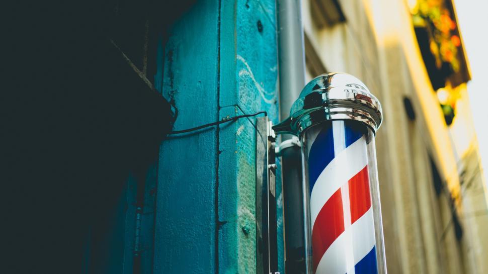 Free Image of Barbershop pole with a blue wall background 