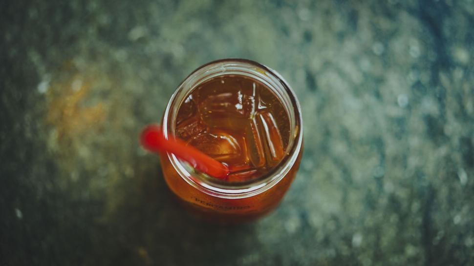 Free Image of Close up of iced tea with red straw on a table 