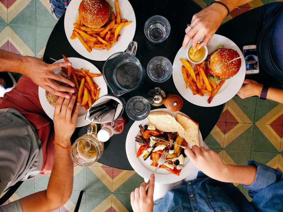 Free Image of Friends sharing a meal at a colorful table 