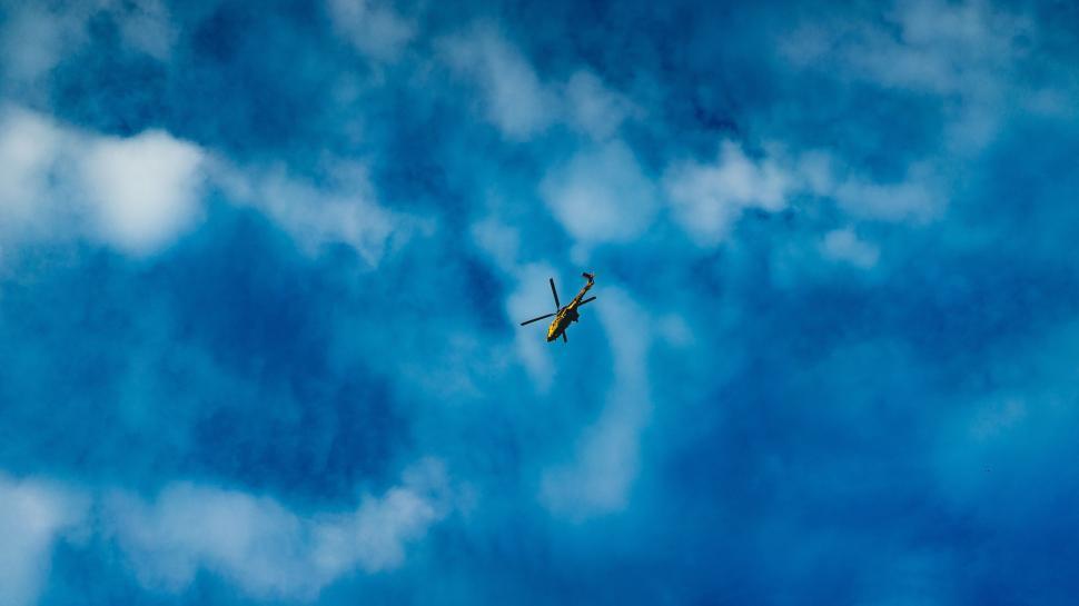 Free Image of Airplane flying through a cloudy blue sky 
