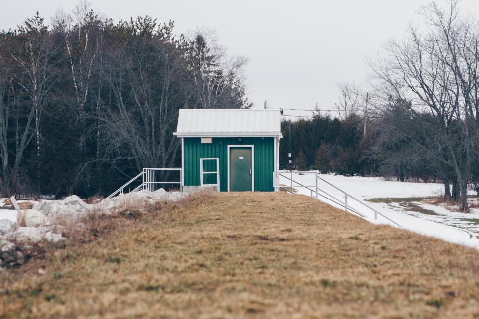Free Image of Small green building in a snowy field 