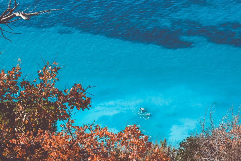 Free Image of Turquoise waters surrounded by autumn foliage 
