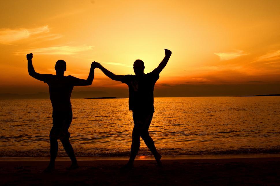 Free Image of Silhouettes holding hands against sunset 