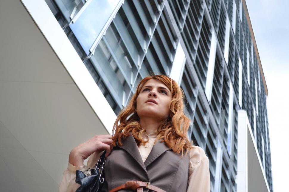 Free Image of Woman looking up at modern architecture 