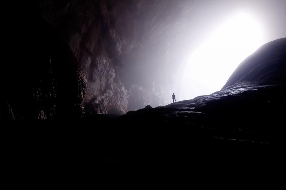 Free Image of Silhouette of a person in a large cave opening 