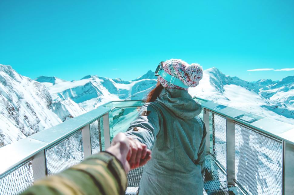 Free Image of Woman leading a partner towards mountain peaks 