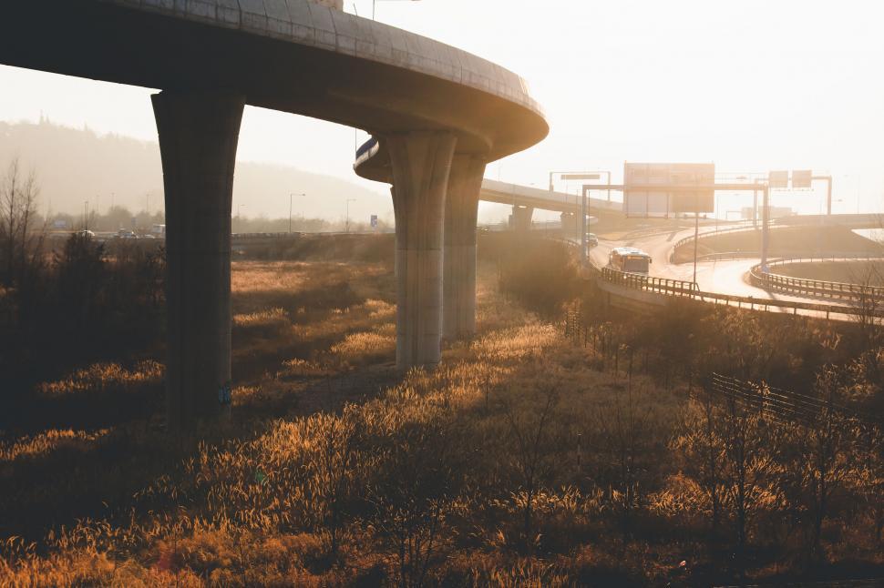 Free Image of Sunset over a freeway interchange with grassy foreground 