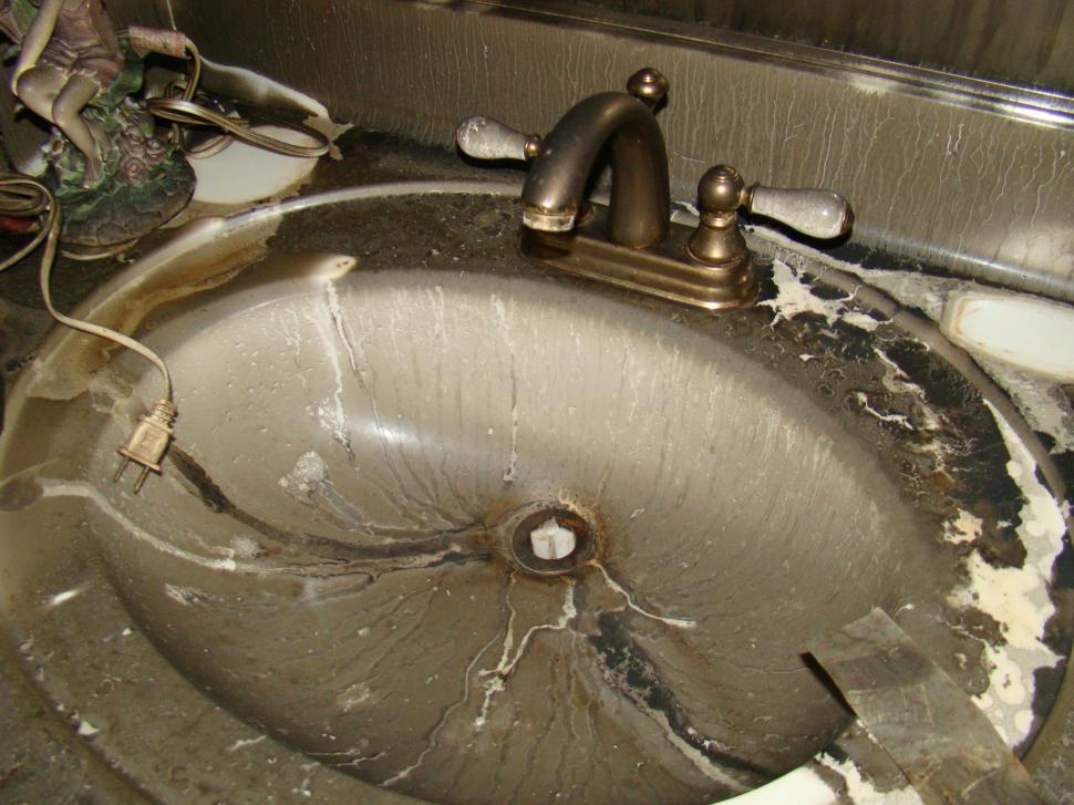 Free Image of Neglected Sink With Broken Faucet in a Grimy Bathroom 