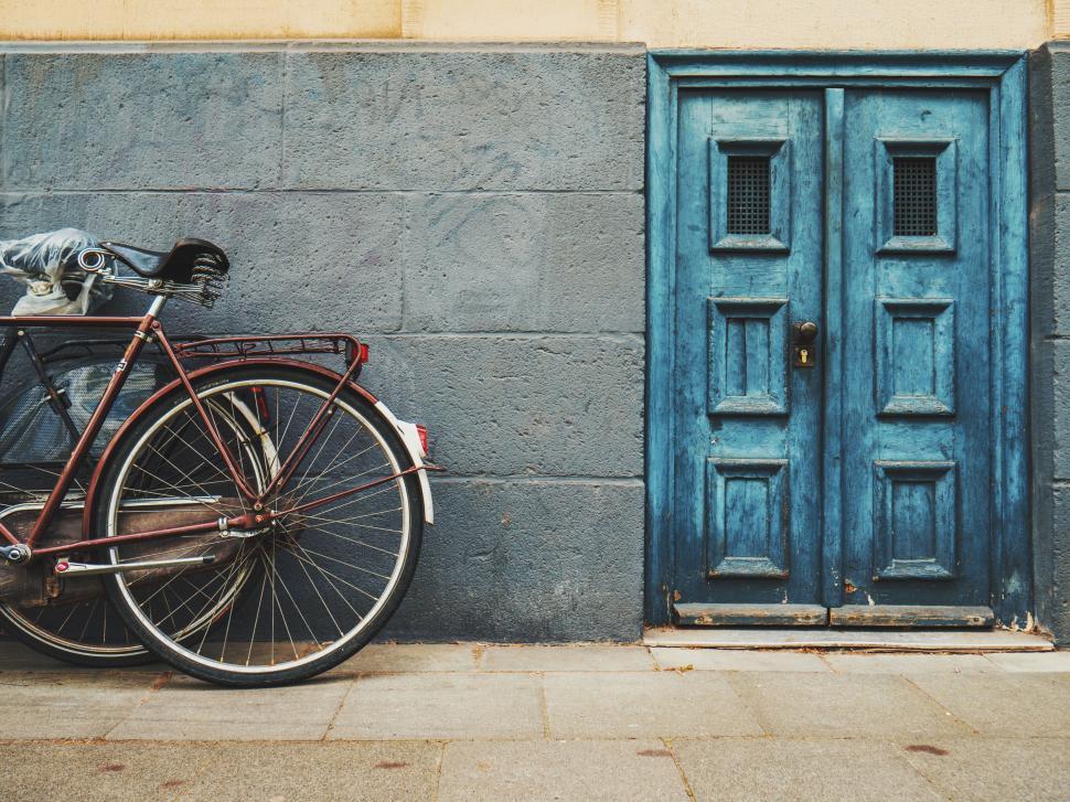 Free Image of Bicycle leaning against vibrant blue doors 