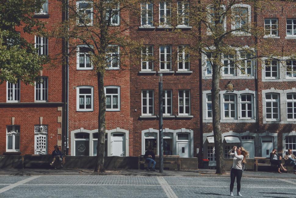 Free Image of Brick Buildings and a Tourist Taking Photos 