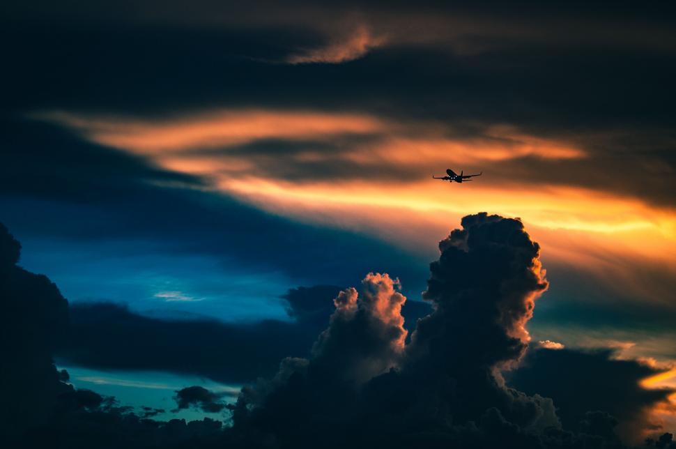 Free Image of Airplane silhouette against dramatic sunset 