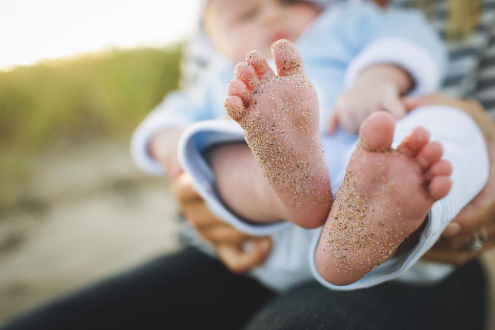 Free Image of Baby feet covered in sand on a beach 