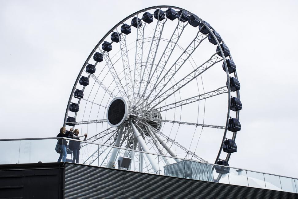 Free Image of Ferris wheel towering over urban skyline 
