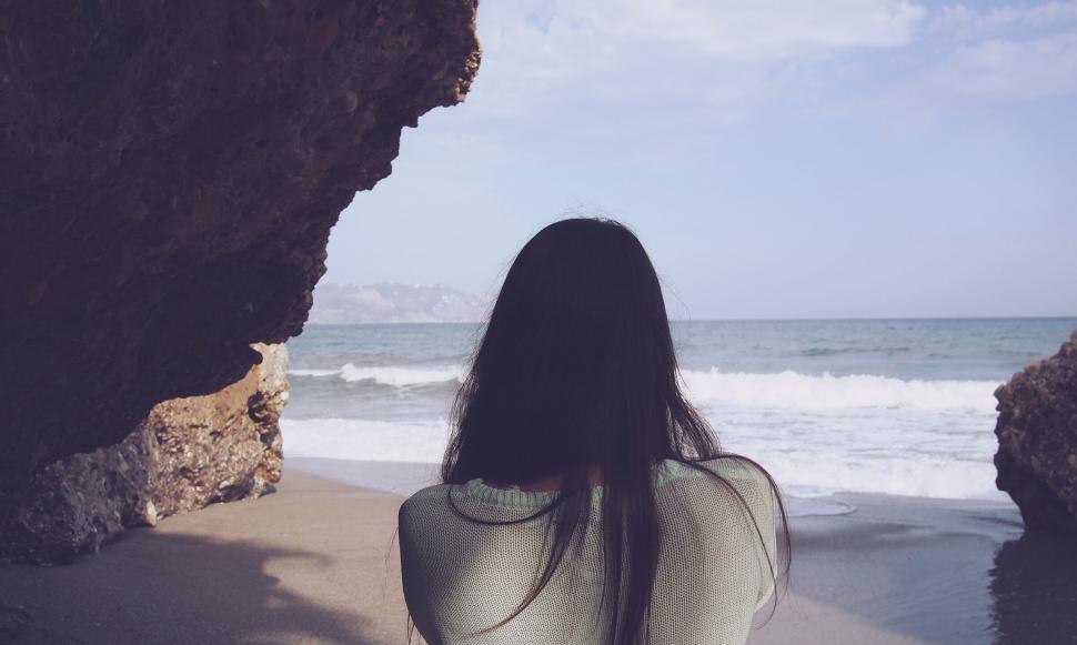 Free Image of Woman gazing at a serene beachscape 