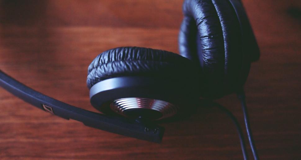 Free Image of Black headphones on a wooden table 