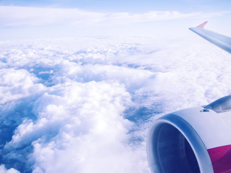 Free Image of Airplane wing over fluffy clouds view 