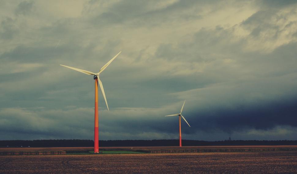 Free Image of Wind turbines against a stormy sky backdrop 