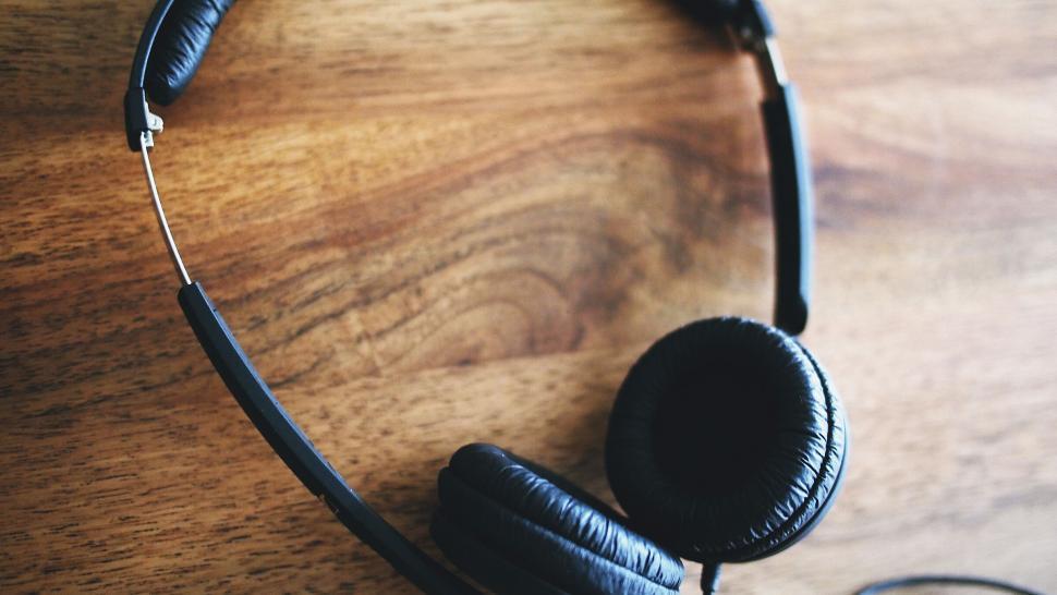 Free Image of Black headphones on wooden surface 