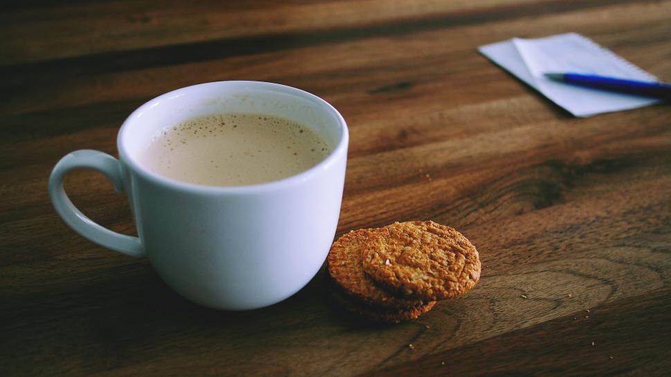 Free Image of Cup of coffee with cookie on wood table 