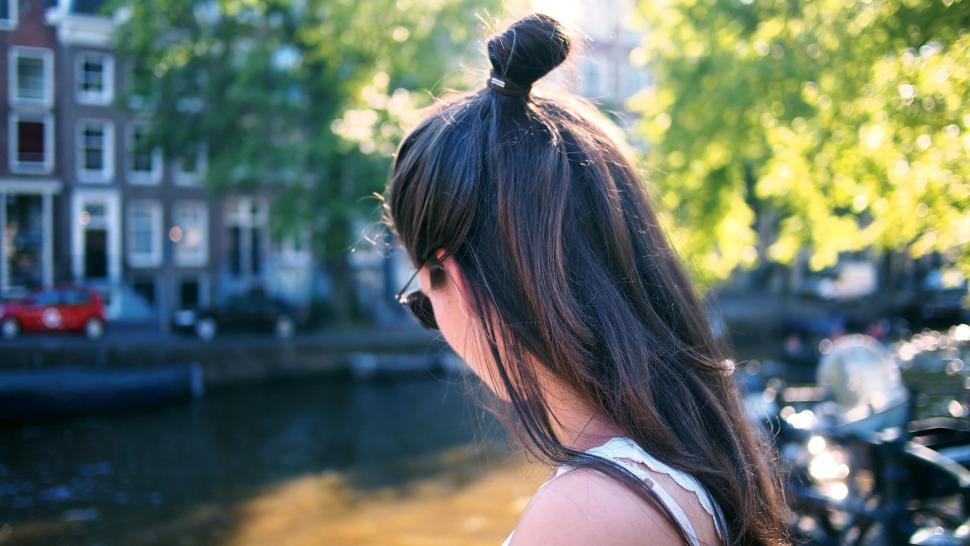 Free Image of Back view of a woman by the canal in Amsterdam 