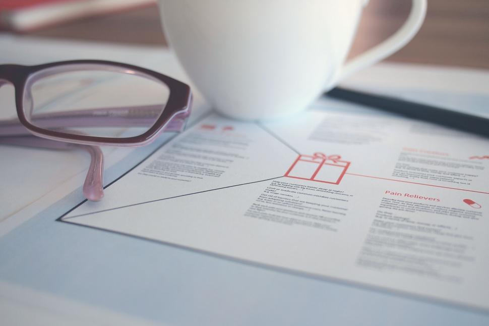 Free Image of Office desk with glasses and a proposal document 